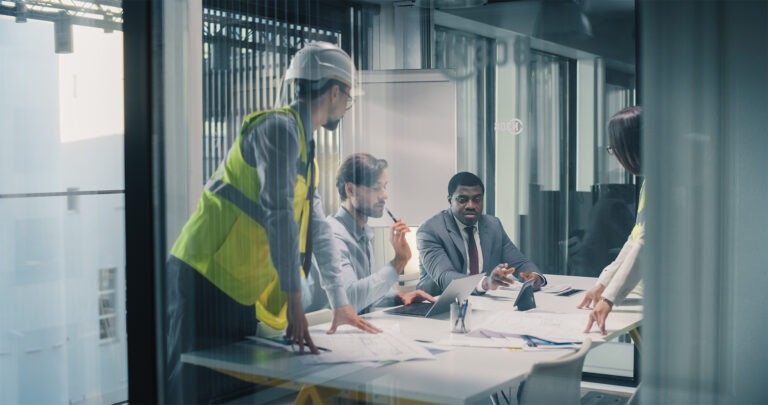 Executives and Engineers Meet in a Glass Conference Room